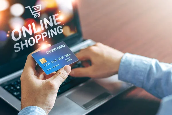 E-commerce and online shopping concept, Business men use laptops and hold credit cards for online shopping at home with copy space. During the Summer Sale holidays