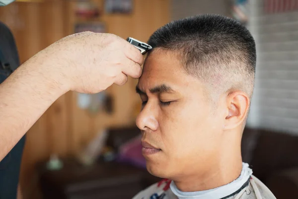 Asyalı Genç Adam Berber Dükkanında Berber Tarafından Elektrikli Makasla Saçlarını — Stok fotoğraf