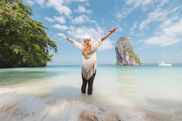 Asian woman standing in the sea and enjoying with beautiful sea and sky in her vacation. Summer holidays and travel concept. Travelling in Thailand.