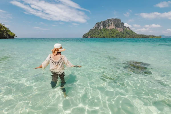 Asian woman standing and playing in the sea and enjoying with beautiful nature in her vacation. Summer holidays and travel concept. Travelling in Thailand.