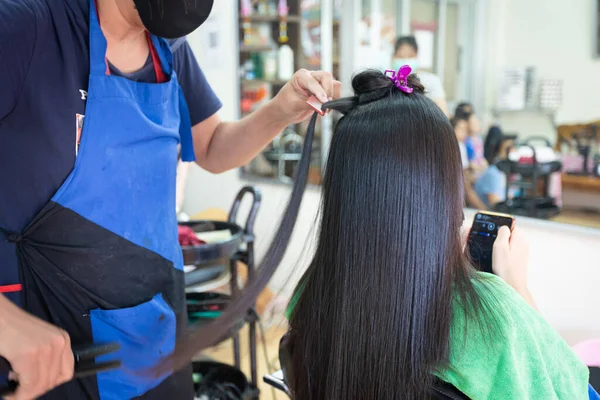 Genç Asyalı Kadın Kuaförden Düz Saç Düzleştirici Alırken Akıllı Telefon — Stok fotoğraf