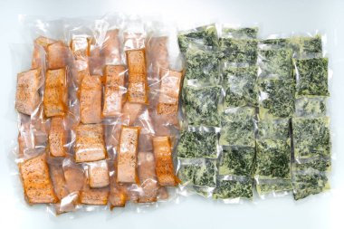 freeze cooked salmon and cheesy creamed spinach in vacuum packs, concept of food preservation, good work from home lunch idea, quick food on bysy day, time-saving meal for lockdown period