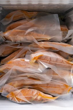 freeze cooked salmon in vacuum packs in freezer of modern refrigerator, concept of food preservation, good work from home lunch idea, quick food on bysy day, time-saving meal for lockdown period