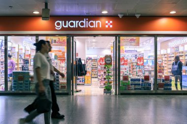Guardian pharmacy store, Malaysias leading health, beauty and personal care chain, at MRT subway station. Passenger looks for some medicines needed before travelling.