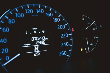 Araç gösterge paneli emniyet kemeri uyarı ışığı ve düşük yakıt uyarı ışığı gösteriyor. Modern arabanın merkezi konsolunda seçici odak ve kontrol paneli kurulmuş.