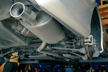 Otomobil tamirhanesinde, egzoz borusunda ve arka fren sisteminde tamir edilmek üzere kaldırma ya da kaldırma sistemi, lastik değiştirme işlemi