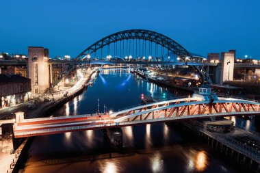 Newcastle on Tyne UK: 30 Mart 2021: Newcastle Gateshead Quayside, with Tyne Bridge and city skyline, long posure during blue hour