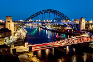 Newcastle on Tyne UK: 30 Mart 2021: Newcastle Gateshead Quayside, with Tyne Bridge and city skyline, long posure during blue hour