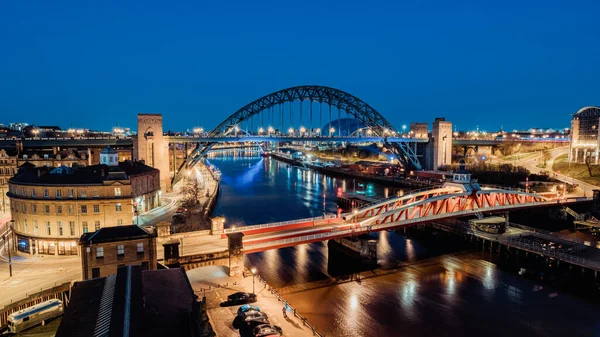Newcastle on Tyne UK: 30 Mart 2021: Newcastle Gateshead Quayside, with Tyne Bridge and city skyline, long posure during blue hour