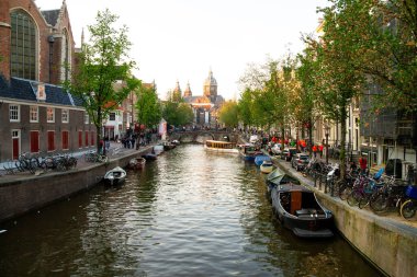 Amsterdam Hollanda - 15 Mayıs 2013: Arka planda bir kilise bulunan Amsterdam Kanalları