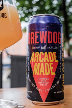 Bristol UK: 28 Temmuz 2025: Bristol Brewdog 'da alkolsüz bir içecek ve güneşli bir havada ahşap masa üzerinde bira keyfi yapmak