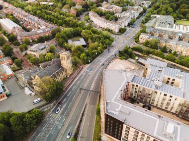 Newcastle on Tyne: 8 Ağustos 2025: Jesmond Road 'un metro istasyonu ve Jesmond Parish Kilisesi ile insansız hava aracı görüntüsü. Newcastle ufuk çizgisinin batısı