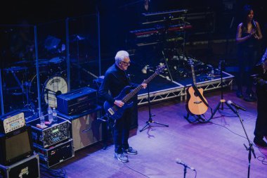 Newcastle on Tyne: 18 Aralık 2025: The Trevor Horn Band O2 City Hall Newcastle 'da konser verdi. Trevor Horn, grubu Newcastle City Hall ile birlikte bir bas gitar tutuyor.