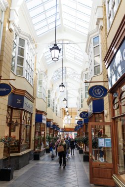 Morpeth UK: 26 Eylül 2025: İnsanlar Morpeth 'teki Sanderson Çarşısı' nda geziniyor. Oyun salonunda her iki tarafta da kuyruk olan dükkanlar yer alıyor. Çatıda büyük pencereler var, içeri güneş ışığı giriyor.