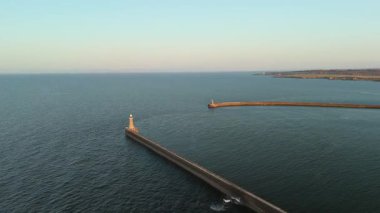 Tynemouth England: 16-08-2025: Gün batımı Kuzey Denizi boyunca Tynemouth İskelesi üzerinde alacakaranlıkta ılık bir parıltı yayar. Hava aracı görüntüleri.
