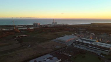 Lynemouth Northumberland: 31 Aralık 2025: Lynemouth Enerji İstasyonu kış sabahı insansız hava aracı görüntülerinin üzerinde duruyor. Güneş doğuyor, Endüstri binalarına ve yakındaki kıyı şeridine ışık tutuyor.