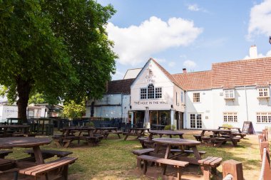 Bristol England: 28 Temmuz 2025: Bristol 'daki Wall Bar' da açık masa. Sahne mavi gökyüzü ve yeşil ağaçlarla aydınlık bir günü gösteriyor.