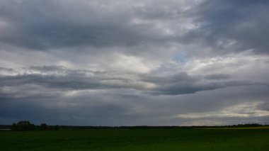 Akşam bulutlu gökyüzü, yeşil tarla üzerinde bulutlu yağmur bulutları..