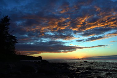 Alacakaranlık mavisi gökyüzü, Baltık Denizi 'nin koyu renkli bulutlarıyla beyaz gecelerde gün batımında, her şey hafif bir şampanya tonuyla sarı-kırmızı renge döner..