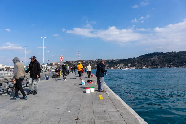 15 Mart 2021 İstanbul - Arnavutkoy plajında balık tutan Türkler