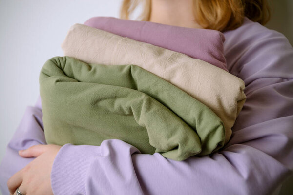 Крупный план женских рук, держащих красивые хлопковые ткани пастельного цвета, избирательный фокус