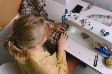 Atölyesinde dikiş makinesiyle çalışan kadınların en iyi görüntüsü.