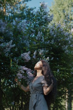 Çiçek açan ağaçların önünde duran güzel Asyalı kadın.