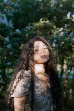 Çiçek açan ağaçların önünde duran güzel Asyalı kadın.