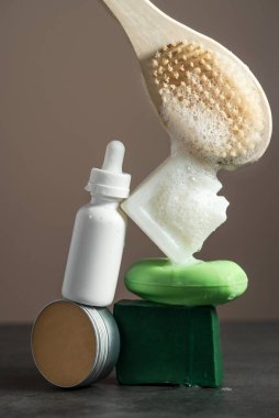 Koyu mermer masa üzerinde ev yapımı merhem ve serum bulunan doğal sabunlar.