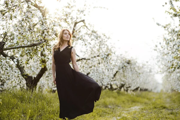 Mooie jonge vrouw in het voorjaar tuin — Stockfoto