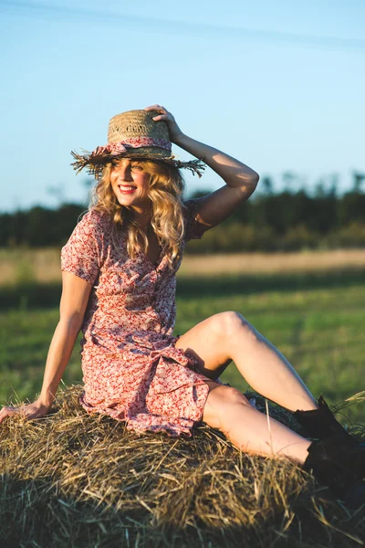 Mooie vrouw op een hooiberg — Stockfoto