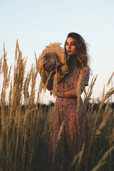 Schöne Frau auf dem Feld bei Sonnenuntergang im Sommer — Stockfoto