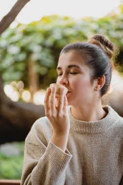 Dışarıdaki kaseden çay içen kadın..