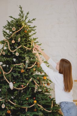 Noel ağacı süsleyen güzel bir genç kadın..