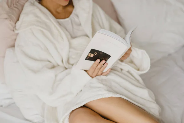 Καλλιεργημένη εικόνα μιας νεαρής γυναίκας που διαβάζει βιβλίο στο κρεβάτι. — Φωτογραφία Αρχείου