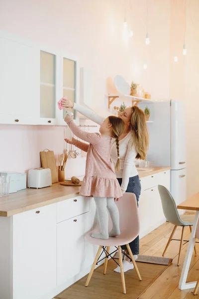 Το κοριτσάκι και η μητέρα της καθαρίζουν την κουζίνα.. — Φωτογραφία Αρχείου