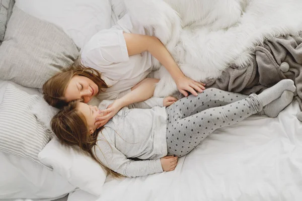 Μητέρα και κόρη ξαπλώνουν στο κρεβάτι με πιτζάμες.. — Φωτογραφία Αρχείου