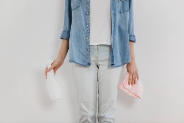 Kırpılmış kadın bez ve sprey deterjan taşıyor..