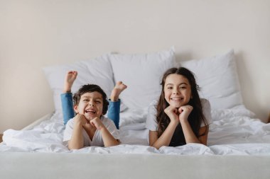 Beyaz yatakta yatan sevimli çocuklar..