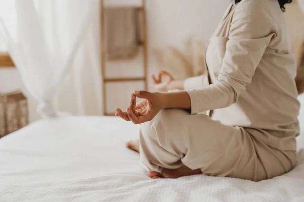 Imagem recortada da mulher afro-americana praticando exercícios de ioga e relaxamento na cama. — Fotografia de Stock