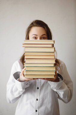 Elinde bir yığın kitap tutan güzel bir kadının portresi..