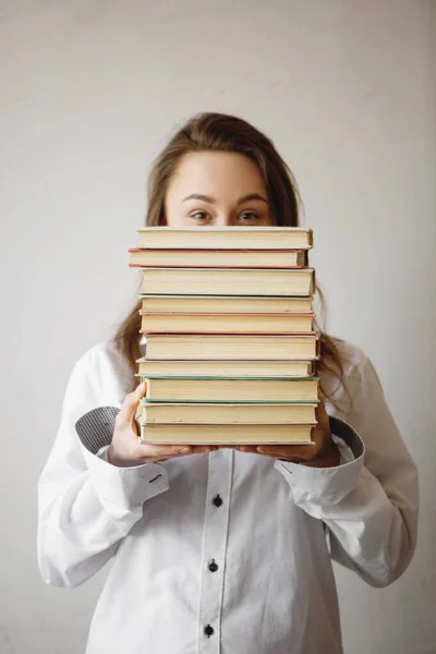 Portret uroczej kobiety trzymającej stos książek. — Zdjęcie stockowe