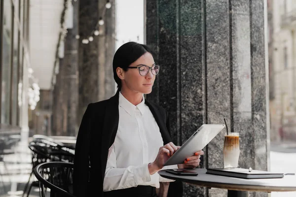 ผู้หญิงธุรกิจที่งดงามกับแท็บเล็ตคอมพิวเตอร์ ดื่มกาแฟที่คาเฟ่ . — ภาพถ่ายสต็อก