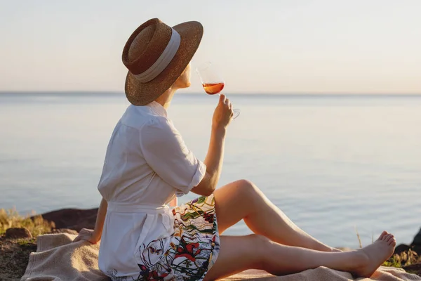 Hermosa dama en sombrero de paja con copa de vino en la playa. —  Fotos de Stock