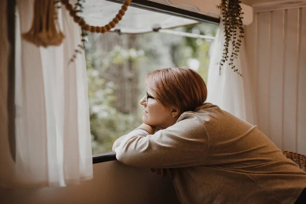 Fröhlich verträumte junge Frau in einem Transporter in der Natur. — Stockfoto