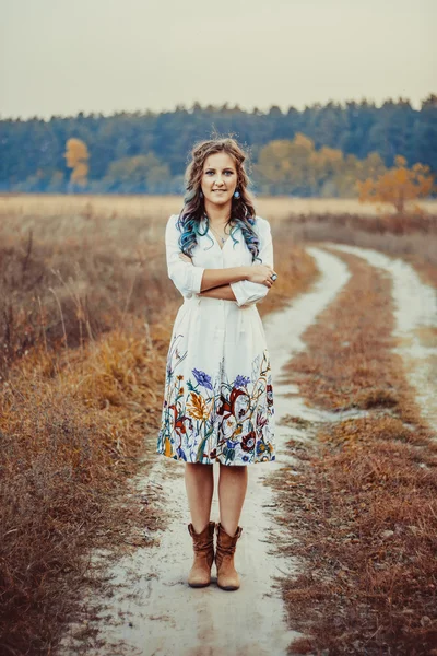 Mujer joven en el camino de otoño — Foto de Stock