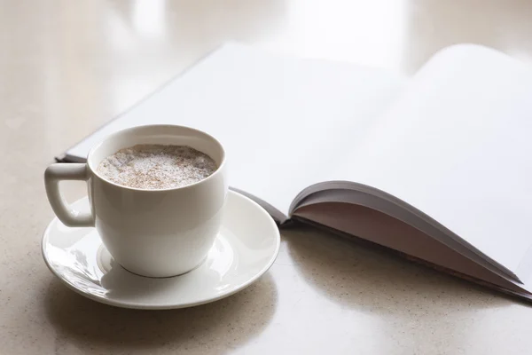 Kopje koffie en geopende boek — Stockfoto