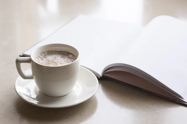 一杯のコーヒーと開かれた本 — ストック写真