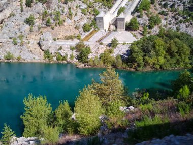 Güneşli, bulutsuz bir günde, dağların arka planına karşı deniz manzarası.