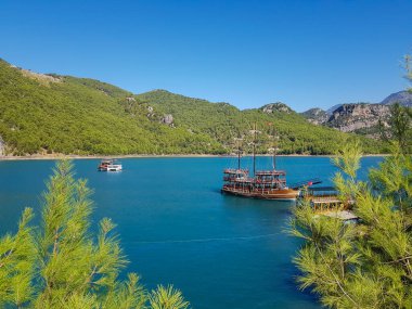 Güneşli, bulutsuz bir günde, dağların arka planına karşı deniz manzarası.